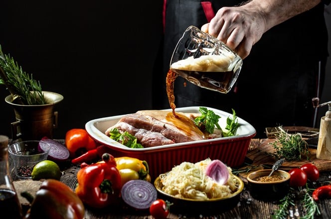 kuhar dodaje pivo kao sastojak pecenci