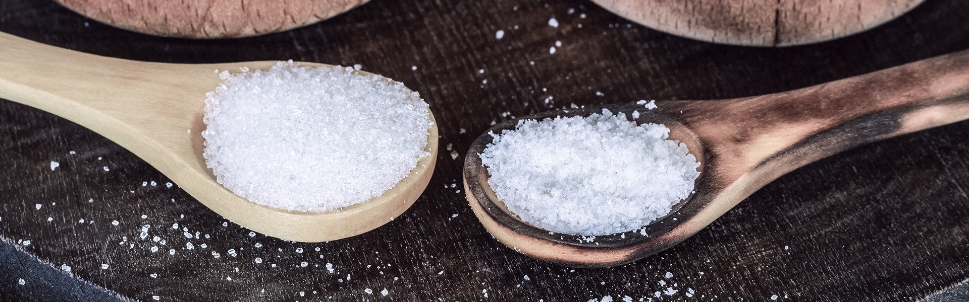 1503445154 salt and sugar on the table in wooden spoons and cups. the main ingredients for cooking: salt and sugar.