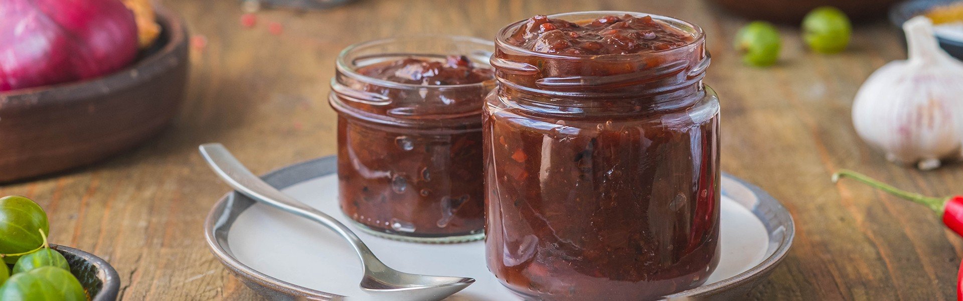 2190841391 Sauce, gooseberry chutney in a glass jar on a wooden background in rustic style. Indian food. Recipes for sauces, seasonings.