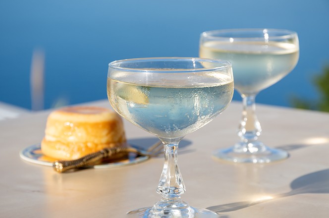 2508740589 Cold sparkling wine, cava or champagne in two coupe glasses on table with blue sea view, French Riviera is summer, France