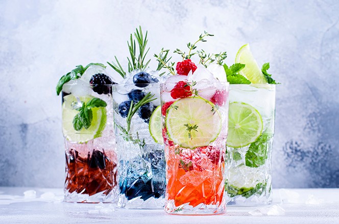 2146663539 Osvje avajuci mojito napitak s borovnicama, kupinama, malinama i limetom, biljem i ledom na sivoj pozadini