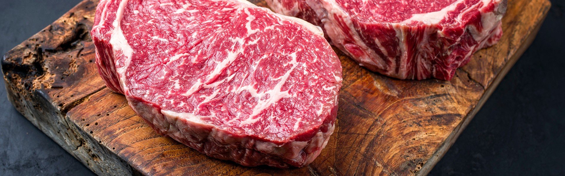 Sirovo suho odle ano wagyu entrecote peceni govedi odrezak u krupnom planu na rustikalnoj drvenoj dasci za rezanje