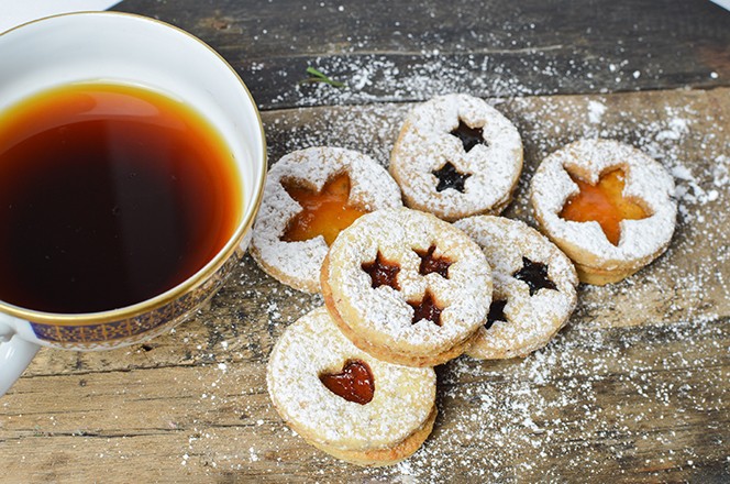 2395591183 Tradicionalni bo icni linzer sendvic kolacici od vanilije, s marmeladom, u prahu sa ecerom, sa alicom kave, na rustikalnoj pozadini