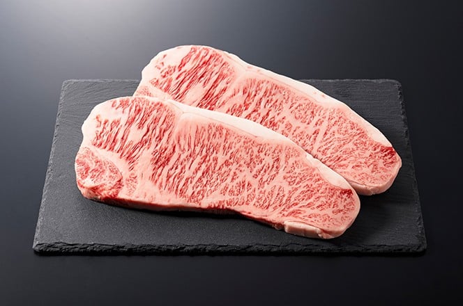 Svje i sirovi govedi odrezak postavljen na kamenu plocu na crnoj pozadini. Wagyu govedi odrezak.