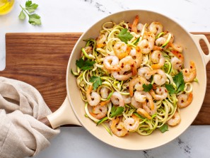 Shrimp and zucchini noodles or zoodles pasta with parmesan and chili flakes cooked in a cast iron pan