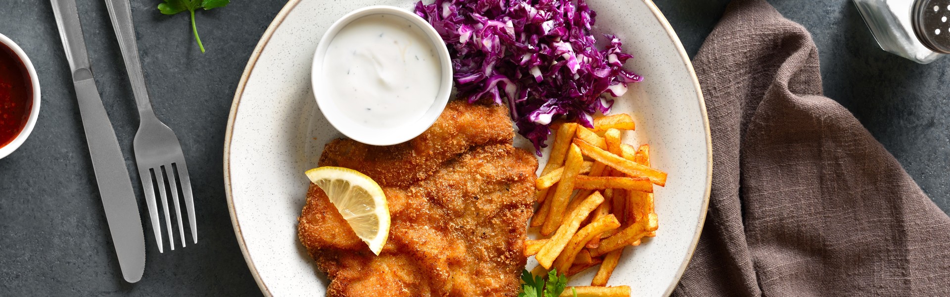 pohano meso, pomfri, umak i kupus salata na tanjuru