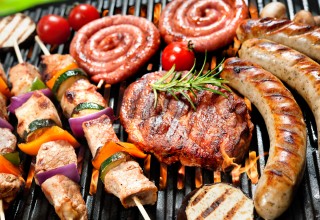 Assorted delicious grilled meat with vegetables over the coals on barbecue