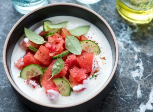 Bowl of cold summer soup made of watermelon, cucumber and buttermilk, horizontal shot on a black marble background
