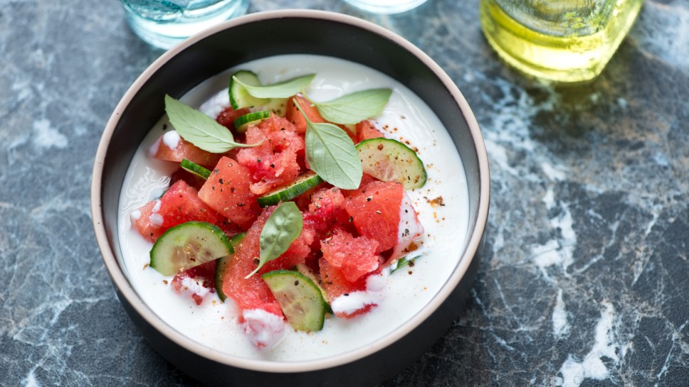 Bowl of cold summer soup made of watermelon, cucumber and buttermilk, horizontal shot on a black marble background