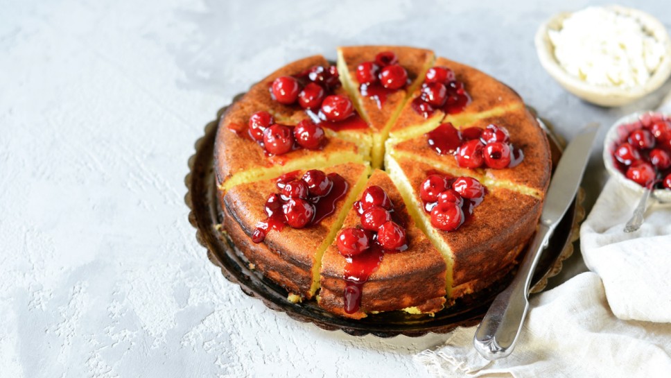 Cottage cheese casserole with cherry sauce on a plate on a gray background