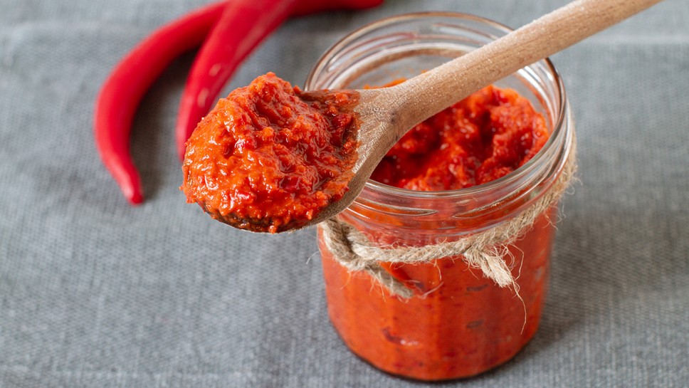 Ajvar in a jar with red chilli peppers
