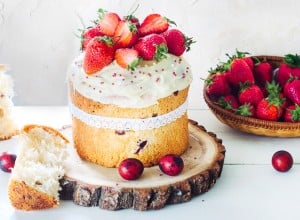 Easter Cake - Russian and Ukrainian Traditional Kulich, Paska Easter Bread. Selective focus. Decorated with frosting and strawberries. Place for text.