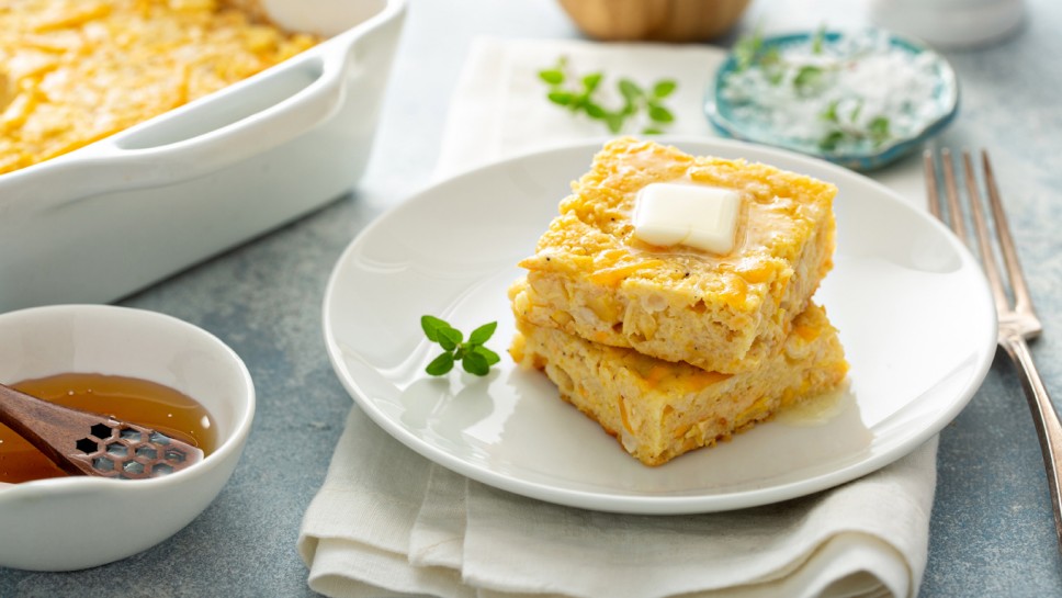 Slices of cheesy cornbread freshly bakedserved with butter and honey, southern food