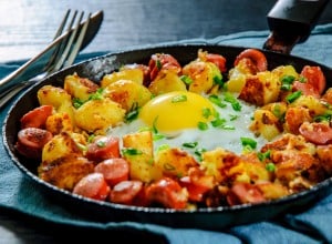 fried egg with sausage and potato in a frying pan