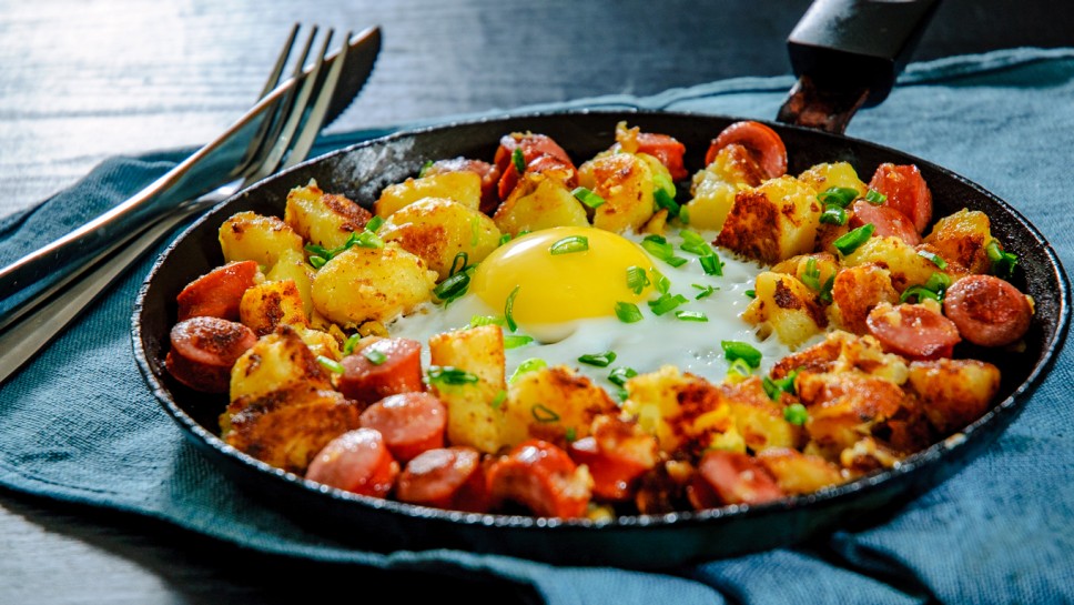 fried egg with sausage and potato in a frying pan