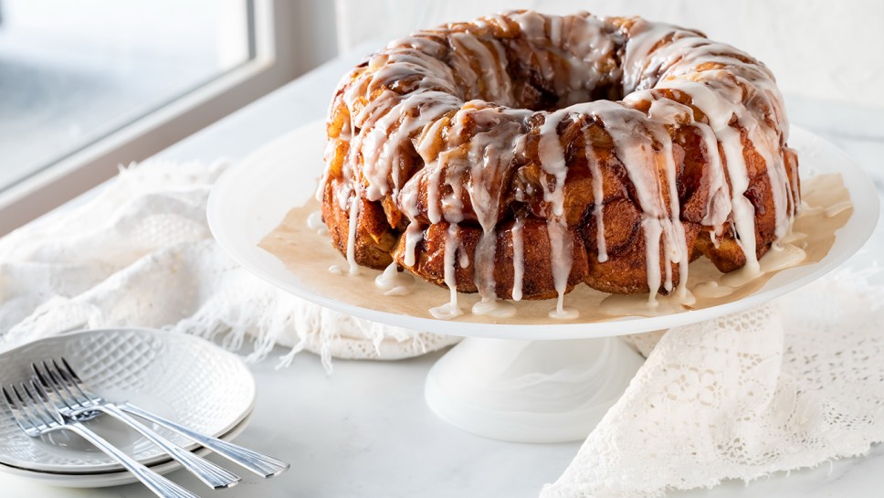 An apple cinnamon pull apart coffee cake drizzled with icing, ready for serving.