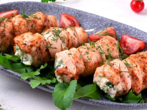 Chicken rolls stuffed with lettuce, egg, cheese, cucumber and sour cream served on the gray plate. Hot appetizing meal