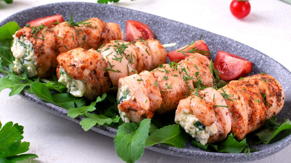 Chicken rolls stuffed with lettuce, egg, cheese, cucumber and sour cream served on the gray plate. Hot appetizing meal