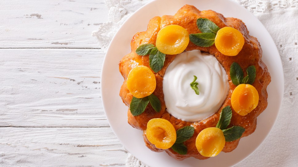 Savarin French dessert with apricots and whipped cream. vertical view from above