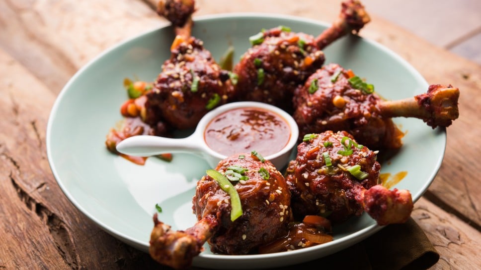 Szechuan Chicken which is a popular Indo-Chinese non vegetarian recipe. served in a plate with chilli sauce. selective focus