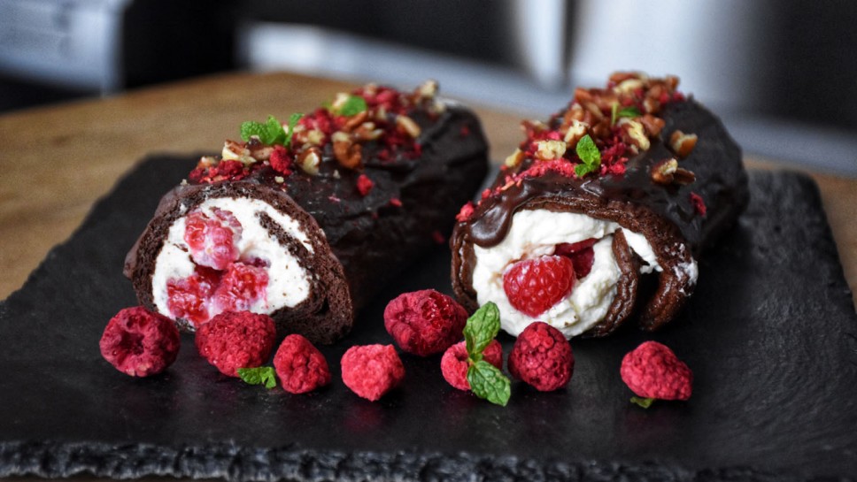 Sweet chocolate roll with whipped cream and raspberries