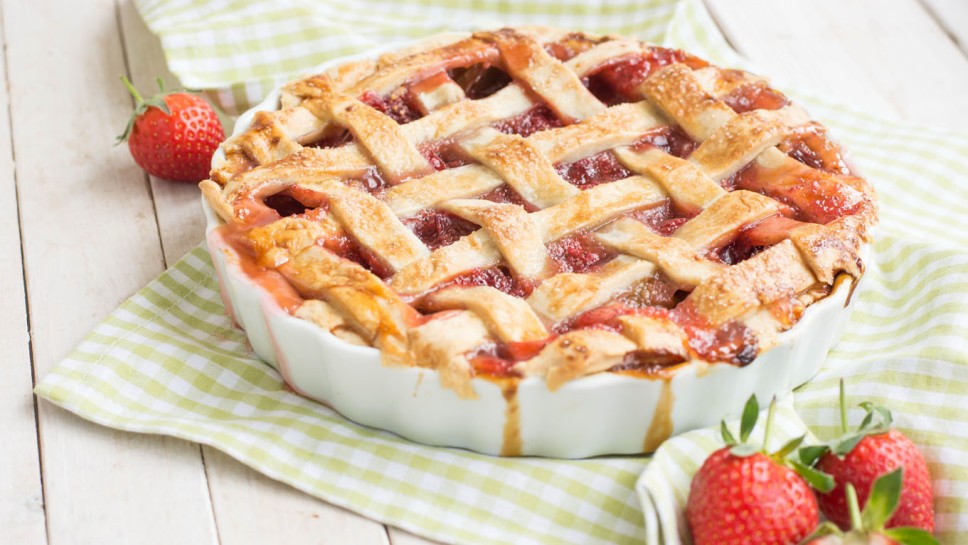 Perfect summer home made pie with rhubarb and strawberry on white background close up selective focus