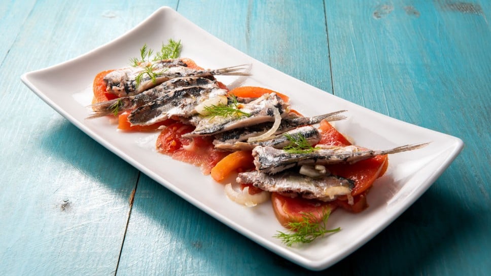 Tray of delicious marinated sardines with tomato and onion, italian food