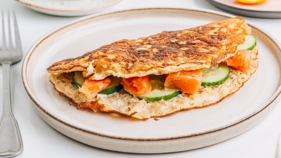 Healthy breakfast, balanced diet concept. Oatmeal pancake stuffed with cream cheese, salmon and cucumber. Selective focus