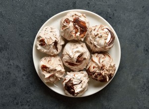 Chocolate meringue cookies on plate over dark stone background. Top view, flat lay