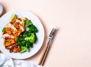 Crispy chicken cutlet with katsu sauce, with white rice and broccoli on a stone table. Top View. Peach Fuzz Background