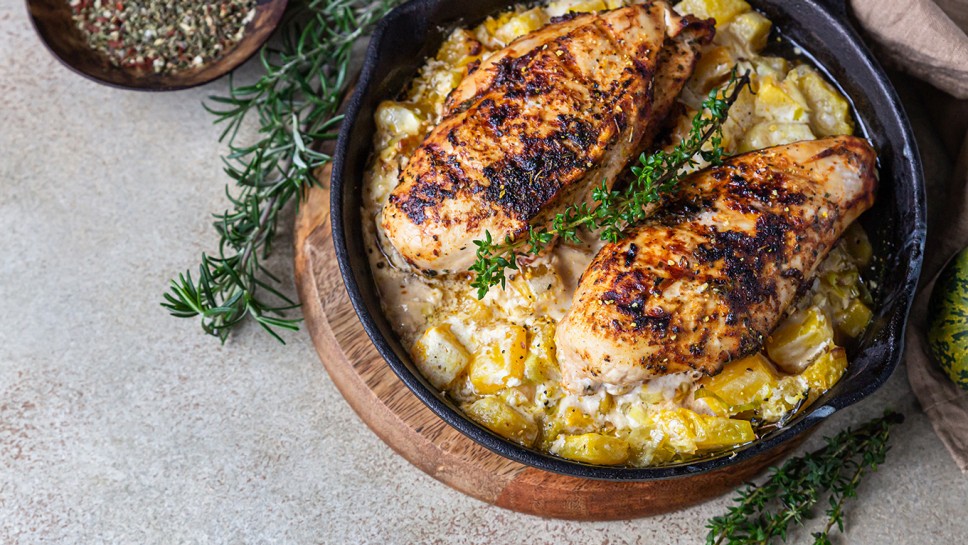 Grilled spicy chicken breast or fillet with pumpkin and aromatic herbs in iron pan. Healthy food. Top view. Selective focus.