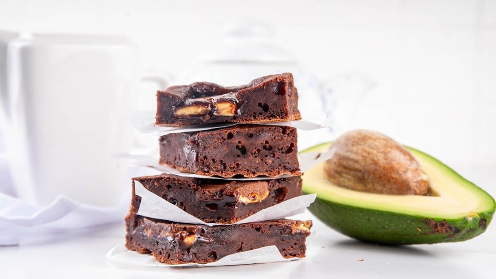 Homemade vegan avocado brownie dessert, sweet healthy alternative vegetarian food dessert with avocado and kerob, on white kitchen table copy space