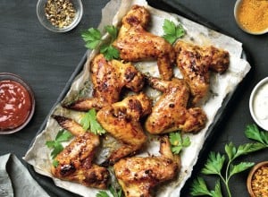 Grilled chicken wings on baking tray over dark background. Top view, flat lay; Shutterstock ID 1034227174; purchase_order: Nisa; job: BBQ 2022.; client: Spar Hrvatska; other: 