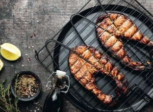 Grilled salmon on iron grill grate on a dark background top view. BBQ seafood. spece for a text; Shutterstock ID 1466838482; purchase_order: Nisa; job: BBQ 2022.; client: Spar Hrvatska; other: 