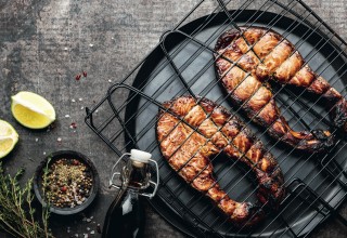Grilled salmon on iron grill grate on a dark background top view. BBQ seafood. spece for a text; Shutterstock ID 1466838482; purchase_order: Nisa; job: BBQ 2022.; client: Spar Hrvatska; other: 