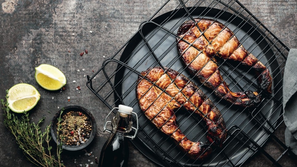 Grilled salmon on iron grill grate on a dark background top view. BBQ seafood. spece for a text; Shutterstock ID 1466838482; purchase_order: Nisa; job: BBQ 2022.; client: Spar Hrvatska; other: 