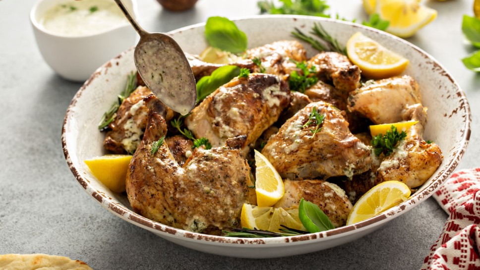Lemon herbed garlic roasted chicken carved into pieces and served on a platter