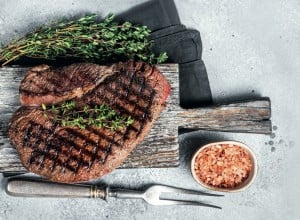 Roasted on grill top sirloin steak with rosemary and thyme. Gray background. Top view; Shutterstock ID 2126438279; purchase_order: Nisa; job: BBQ 2022.; client: Spar Hrvatska; other: 
