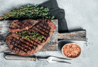 Roasted on grill top sirloin steak with rosemary and thyme. Gray background. Top view; Shutterstock ID 2126438279; purchase_order: Nisa; job: BBQ 2022.; client: Spar Hrvatska; other: 