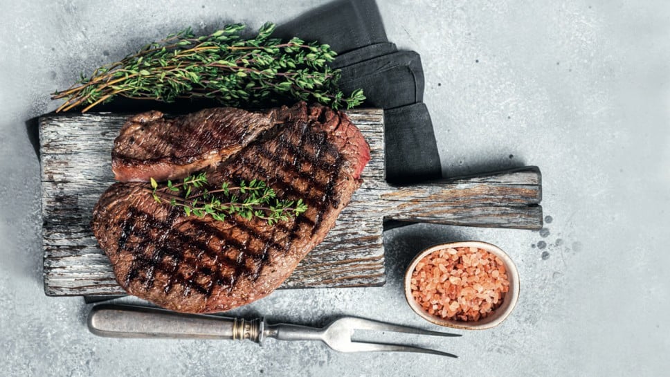 Roasted on grill top sirloin steak with rosemary and thyme. Gray background. Top view; Shutterstock ID 2126438279; purchase_order: Nisa; job: BBQ 2022.; client: Spar Hrvatska; other: 