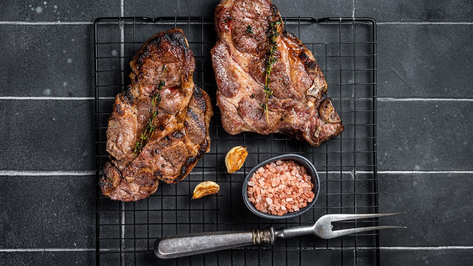 BBQ Grilled Pork loin steaks, neck meat. Black background. Top view.