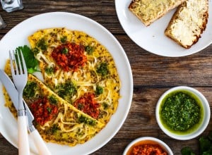 2427965113 Tagliatelle omelet - scrambled eggs with mozzarella cheese, tagliatelle, basil and tomato pesto on wooden table