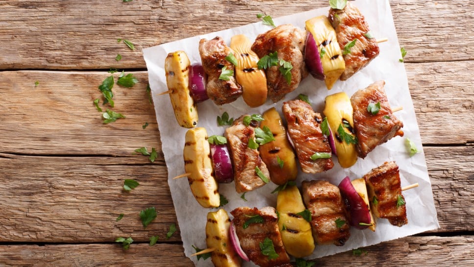 Rustic juicy kebabs of pork with apples and red onions close-up on parchment on the table. Vertical top view from above
; Shutterstock ID 1109551373; purchase_order: Nisa; job: BBQ 2022.; client: Spar Hrvatska; other: 