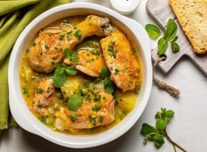 Spring Chicken casserole made with potato, leek, green pea,  white wine and Spring greens, mint and green onion. Top view.