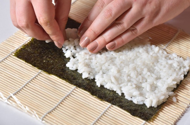 osoba priprema sushi sa rizom