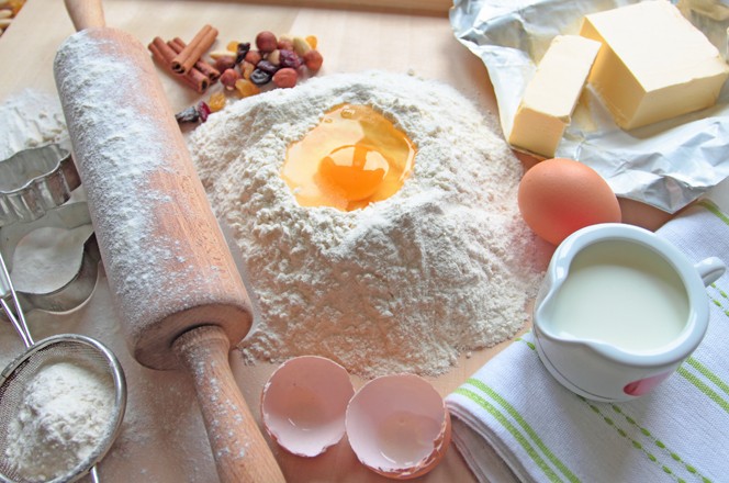 priprema za tijesto - brasno, jaje, mlijeko i valjak na stolu