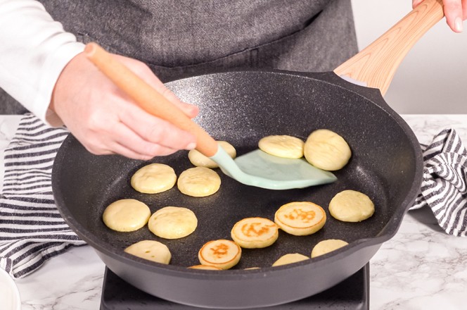 Step by step. Frying mini pancake cereal in a nonstick frying pan.