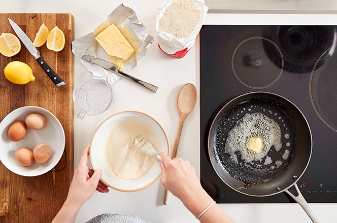 1607118691 Pogled odozgo na enu u kuhinji kako mije a sastojke za palacinke ili krepove povodom Dana palacinki.
