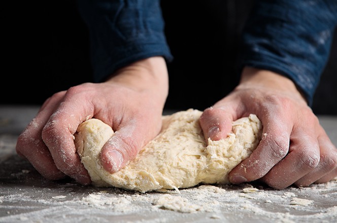 1775502107 ruke mijese tijesto za kruh, tjesteninu ili pizzu, izbliza. Krupan plan ruku pekara kako mijesi tijesto.
