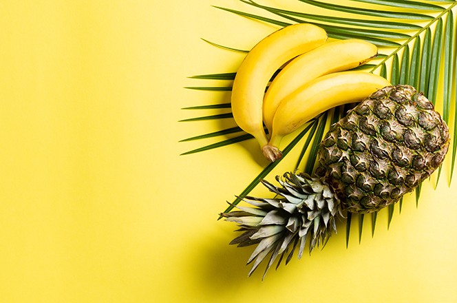 1854545818 Ananas, banana i tropski list palme na utoj podlozi.